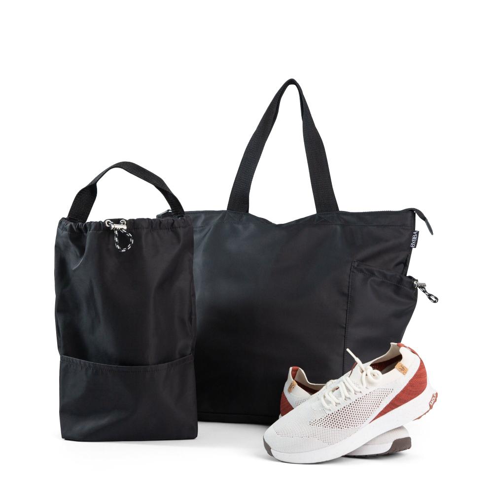 Large black bag with Large black tote beside a pair of white sneakers