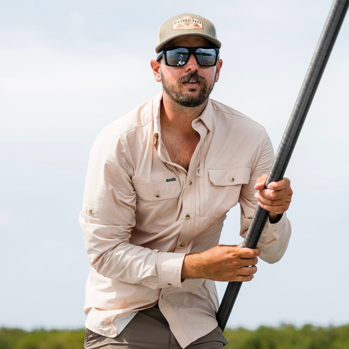 man wearing peach plaid shirt gripping pole