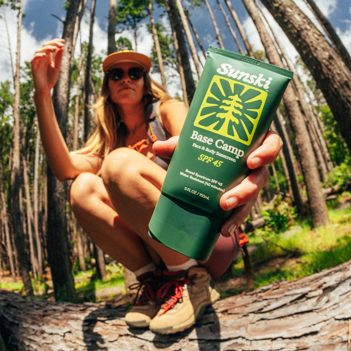 a woman holding Base Camp SPF 45 sunscreen