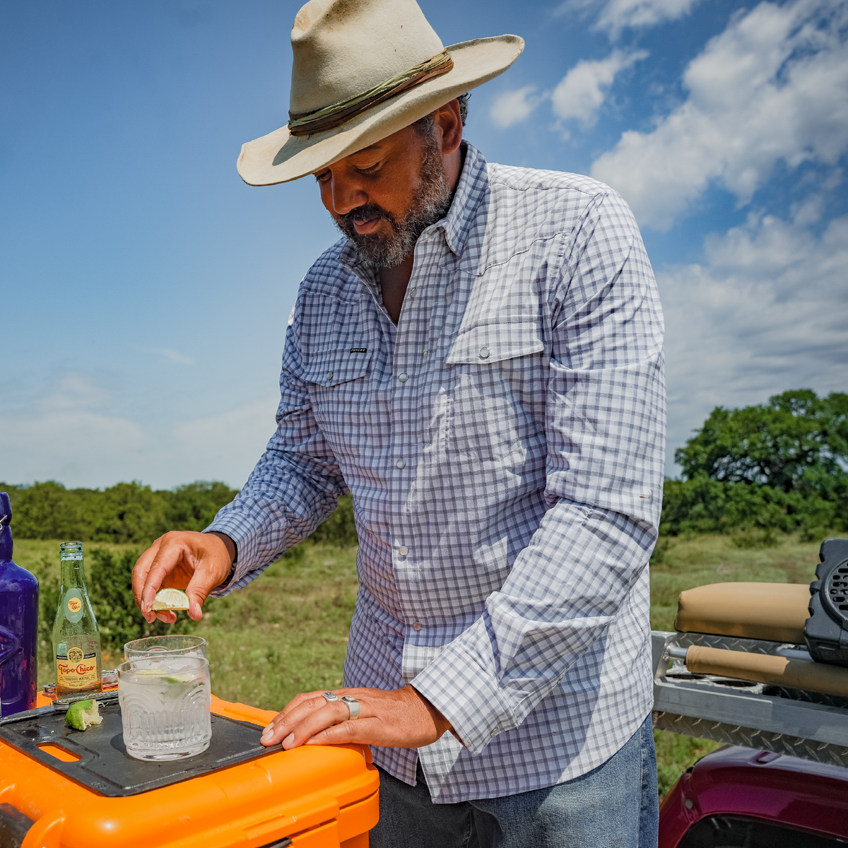 man fixing drink in blue plaid shirt