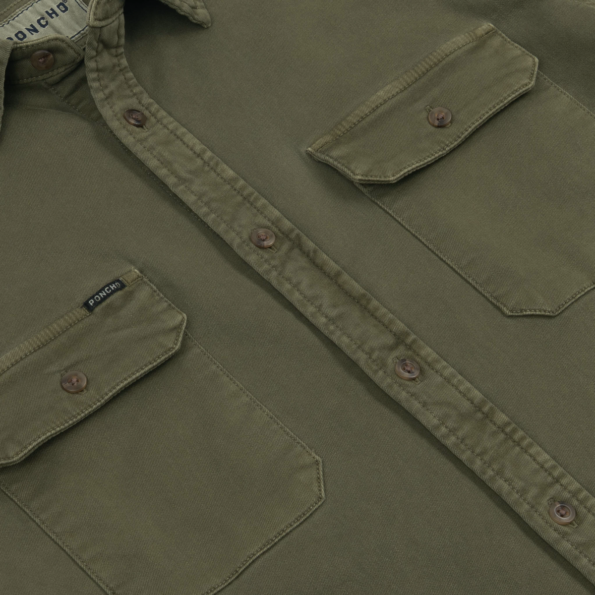Close-up of the buttoned front and chest pockets on The Buck Snort outdoors shirt in olive green fabric.