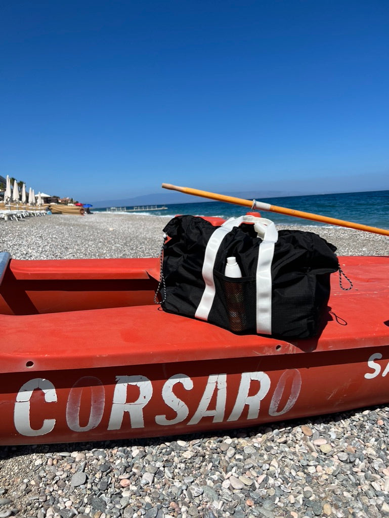 black bag on a red boat on the beach 