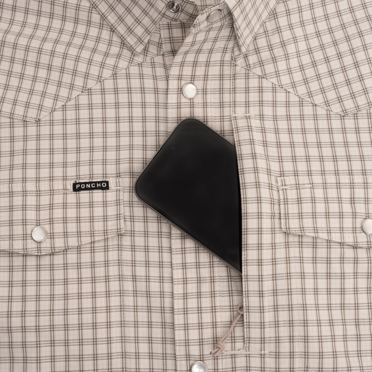 Phone in pocket of brown plaid pearl snap