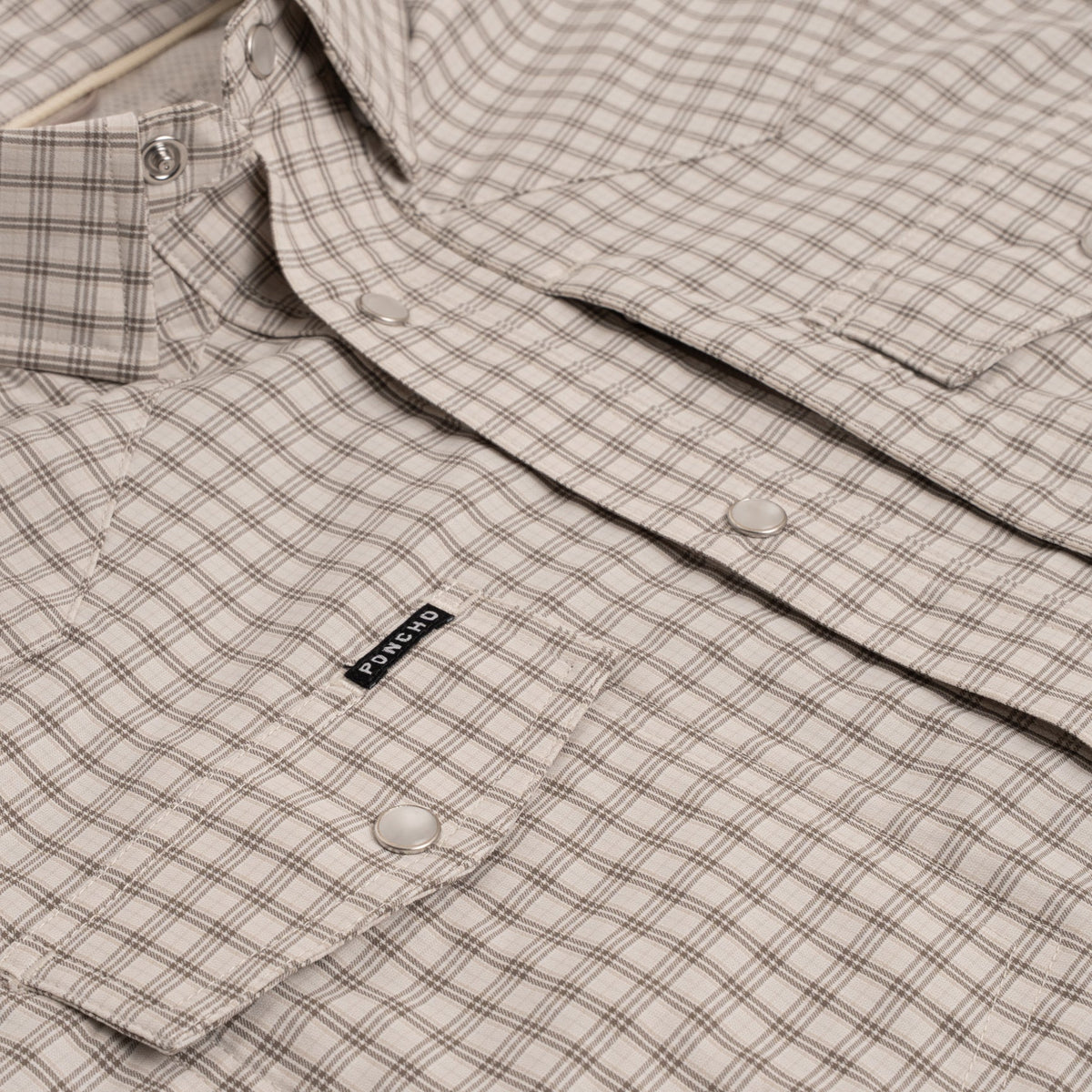 Close up photo of brown plaid pearl snap buttons