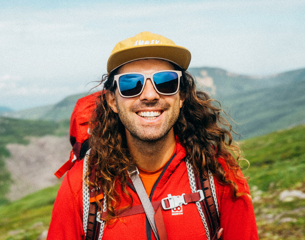 STORY man backpacking in sunski couloir dune galaxy and sunski team hat
