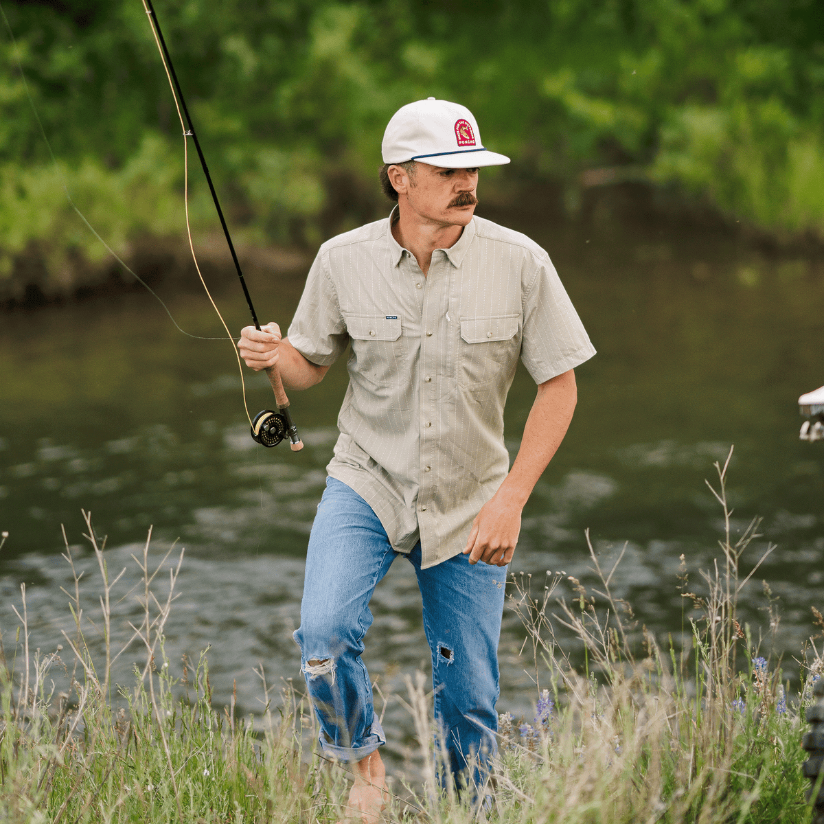 Man fishing in short sleeve green button down