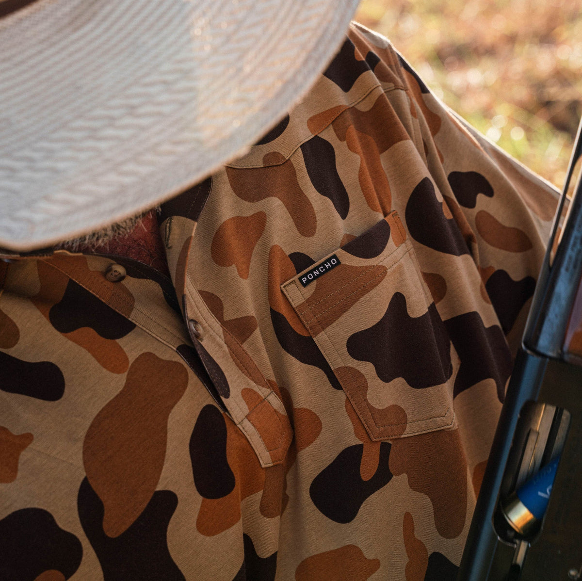 man with shotgun wearing camo polo shirt
