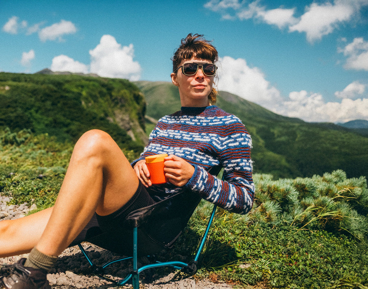 STORY woman in sunski ferrata olive citrine amber drinking coffee in the mountains