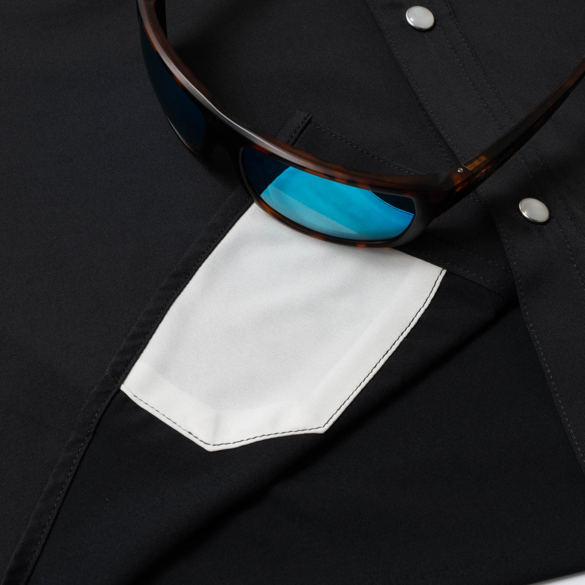 photo of sunglasses with lens cleaner on black shirt