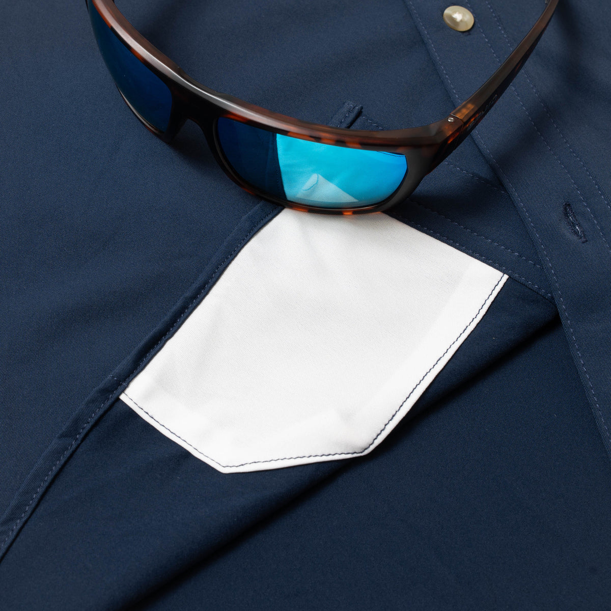 Photo of sunglasses with lens cleaner on navy shirt