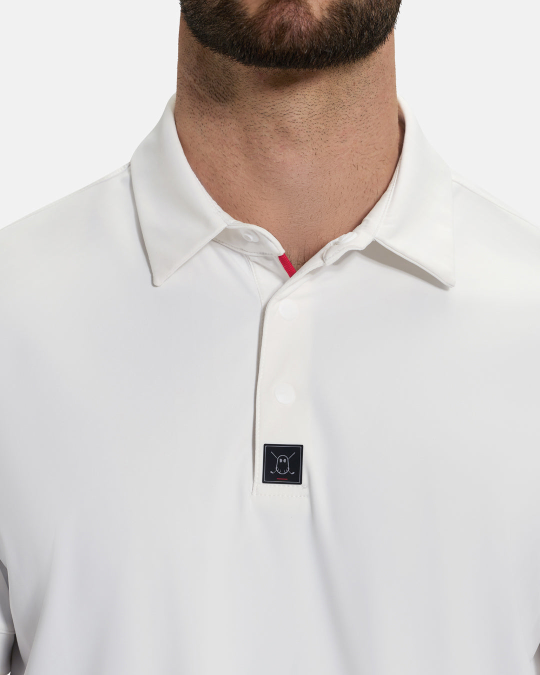 Front Closeup View of Optic White Ghost Golf Core Polo on White Male Model #color_white