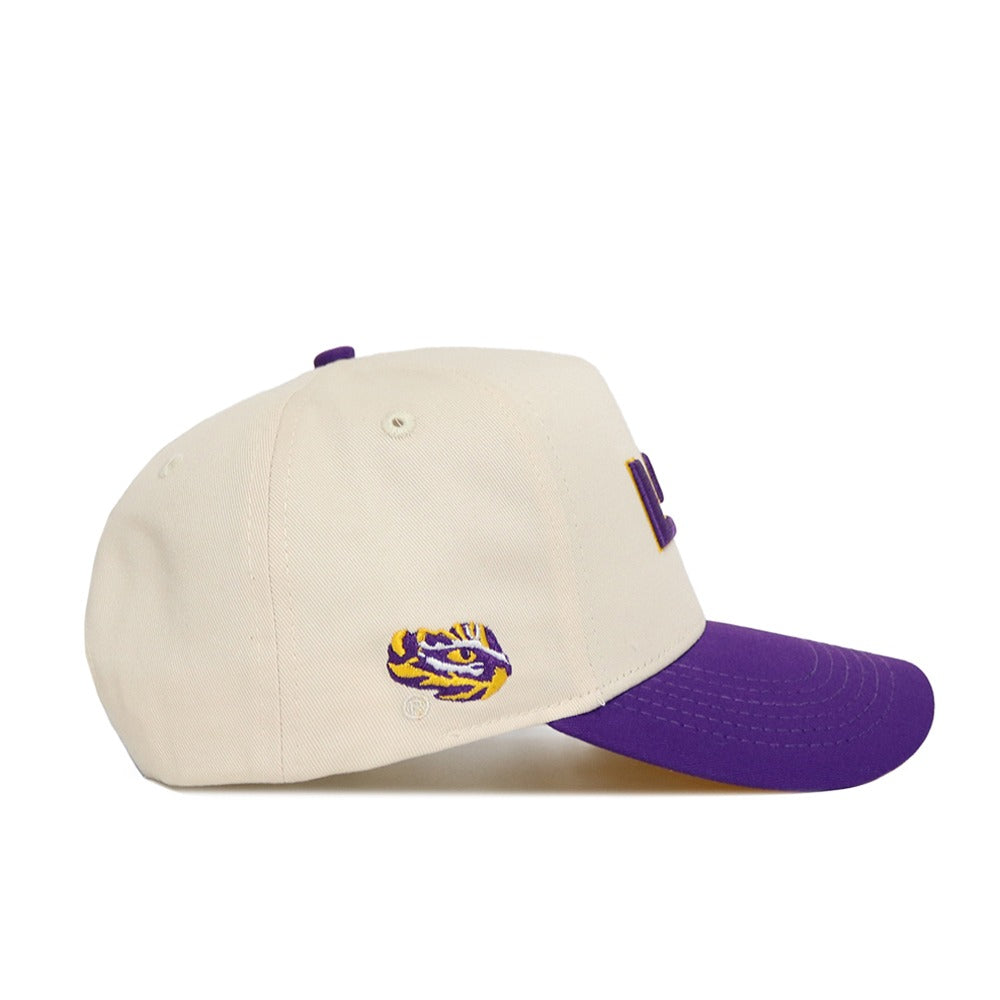 The No Rivals Classic LSU Hat (B2B) is a cream baseball cap with a purple brim, featuring an embroidered tiger head in purple and yellow. Made from high-quality cotton with a snap back for an adjustable, one-size-fits-most fit.