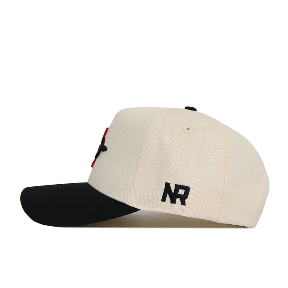 The No Rivals Classic San Diego State Hat (B2B) is a cream snapback with a black brim, seen from the side. Made of quality cotton, it has a structured fit and black embroidered NR letters on the side.