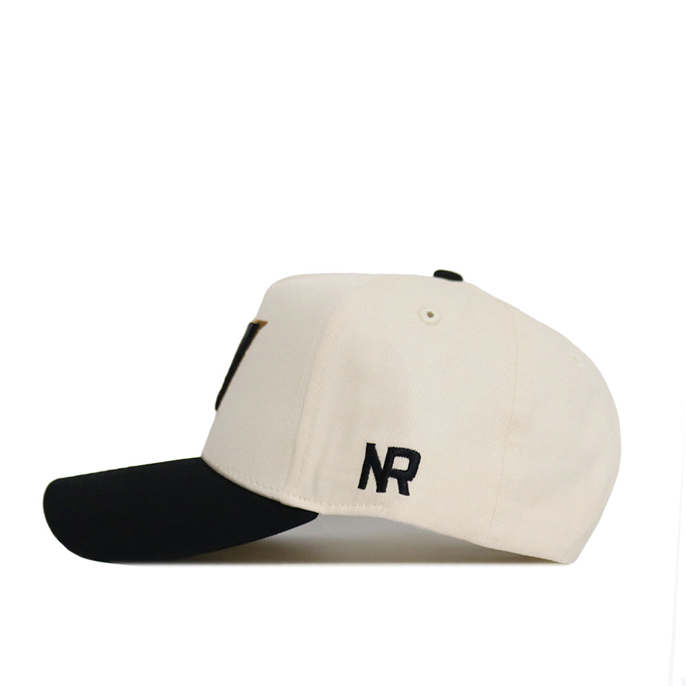 Side view of the Classic Vanderbilt Hat (B2B) by No Rivals, a beige snapback with black curved brim, NR embroidery on the side, stitching details, and adjustable strap—ideal for your gameday fit.