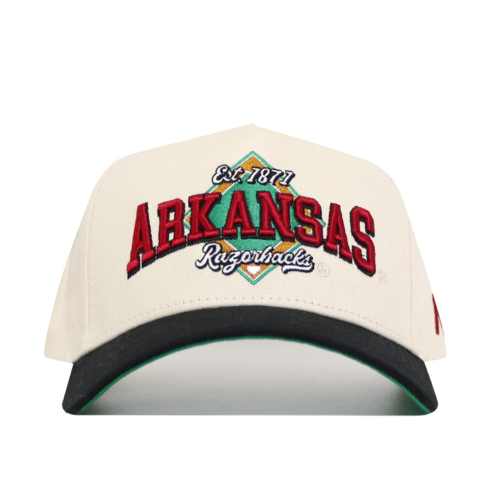 The No Rivals Arkansas Ballpark Hat features premium white cotton, "ARKANSAS Razorbacks Est. 1871" embroidered in red, green, and black on the front, plus a black curved brim with green underside for an officially licensed look.