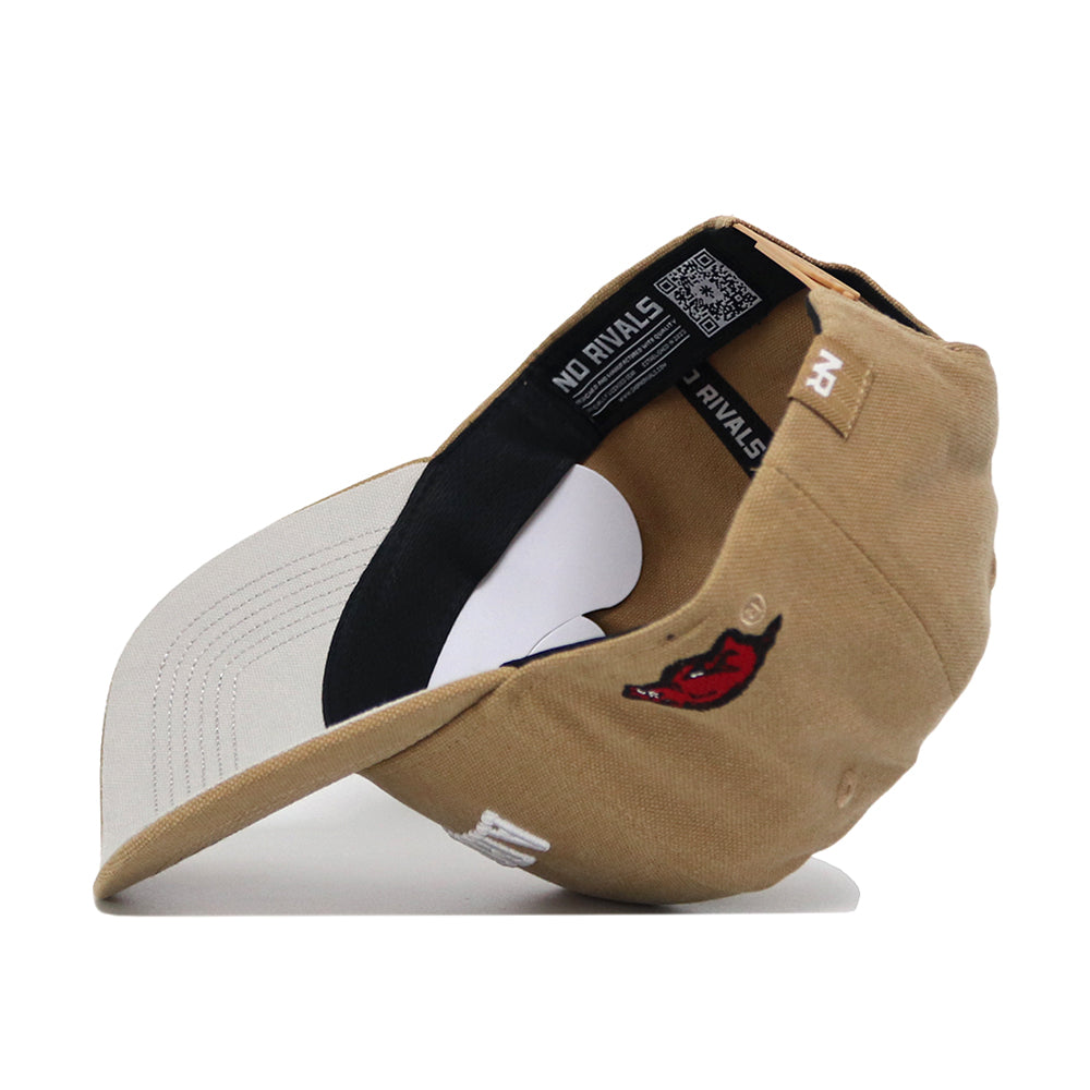 The Arkansas Rustic Hat is a tan cotton-canvas snapback baseball cap with a light gray brim, embroidered logos—including a red devil face on the side—plus a structured fit and sturdy build, shown inside out to reveal its label.
