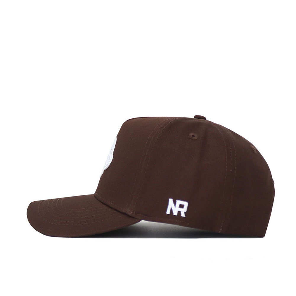 The Boise State Americano Hat is a brown snapback cap shown from the side, with white embroidered NR initials on the back panel. Made of high-quality cotton, it features a flat brim, structured fit, and visible stitching details.