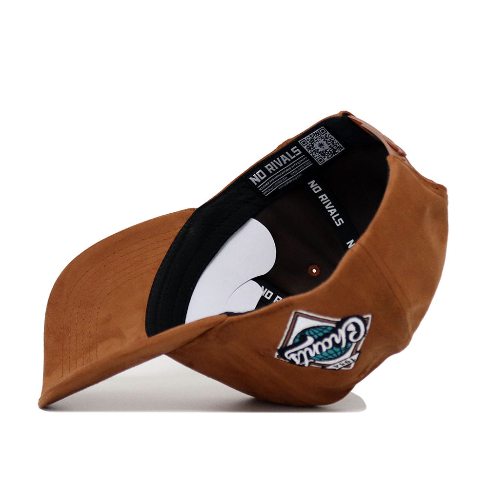 A brown Coastal Carolina Heritage Hat by No Rivals is turned upside down to display the inside NO RIVALS label, while its front features a colorful embroidered patch.