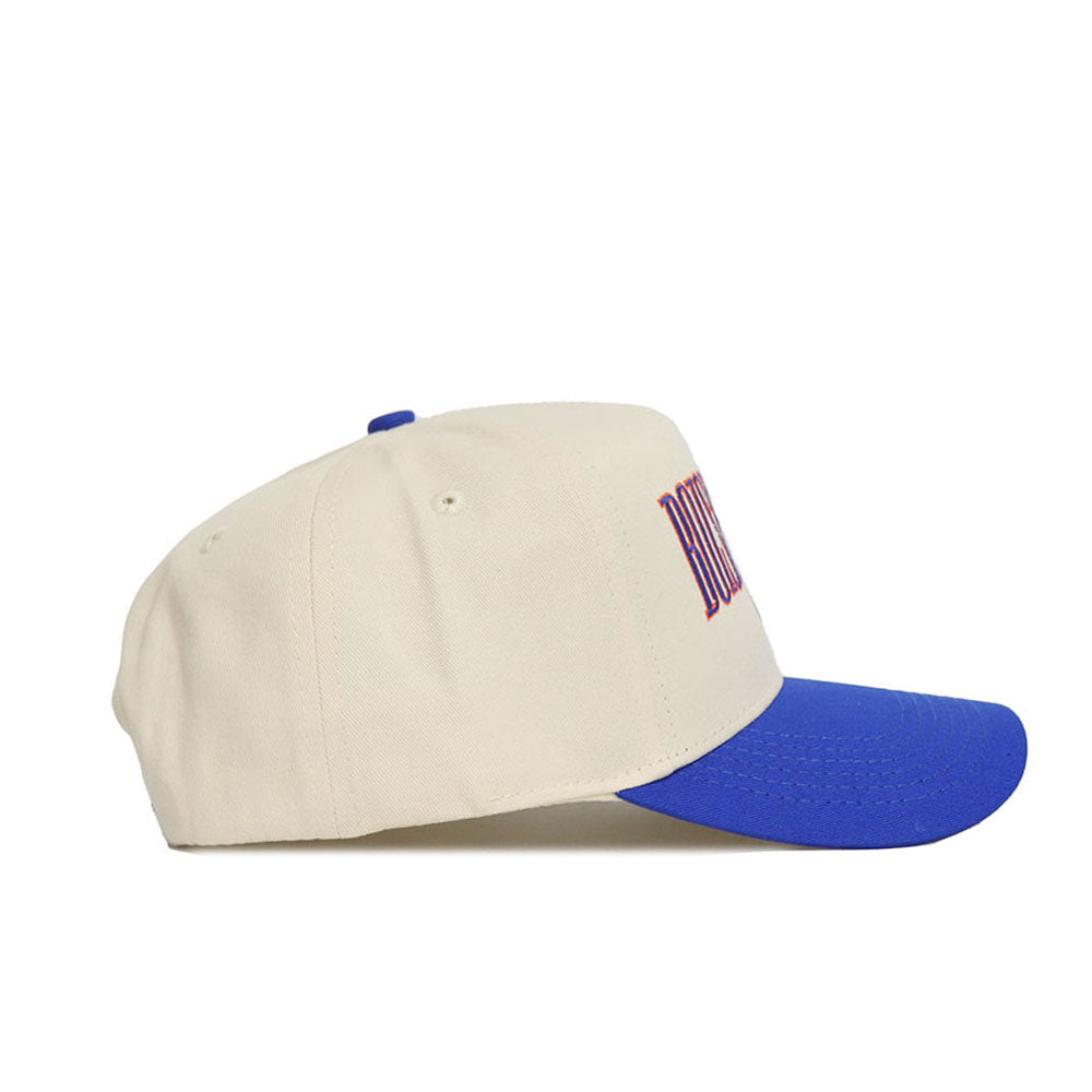 The No Rivals Boise State Retro Block Hat - Classic Colors is a beige cotton snapback with a blue brim, shown side-on. The front panel displays partially visible red embroidered text.