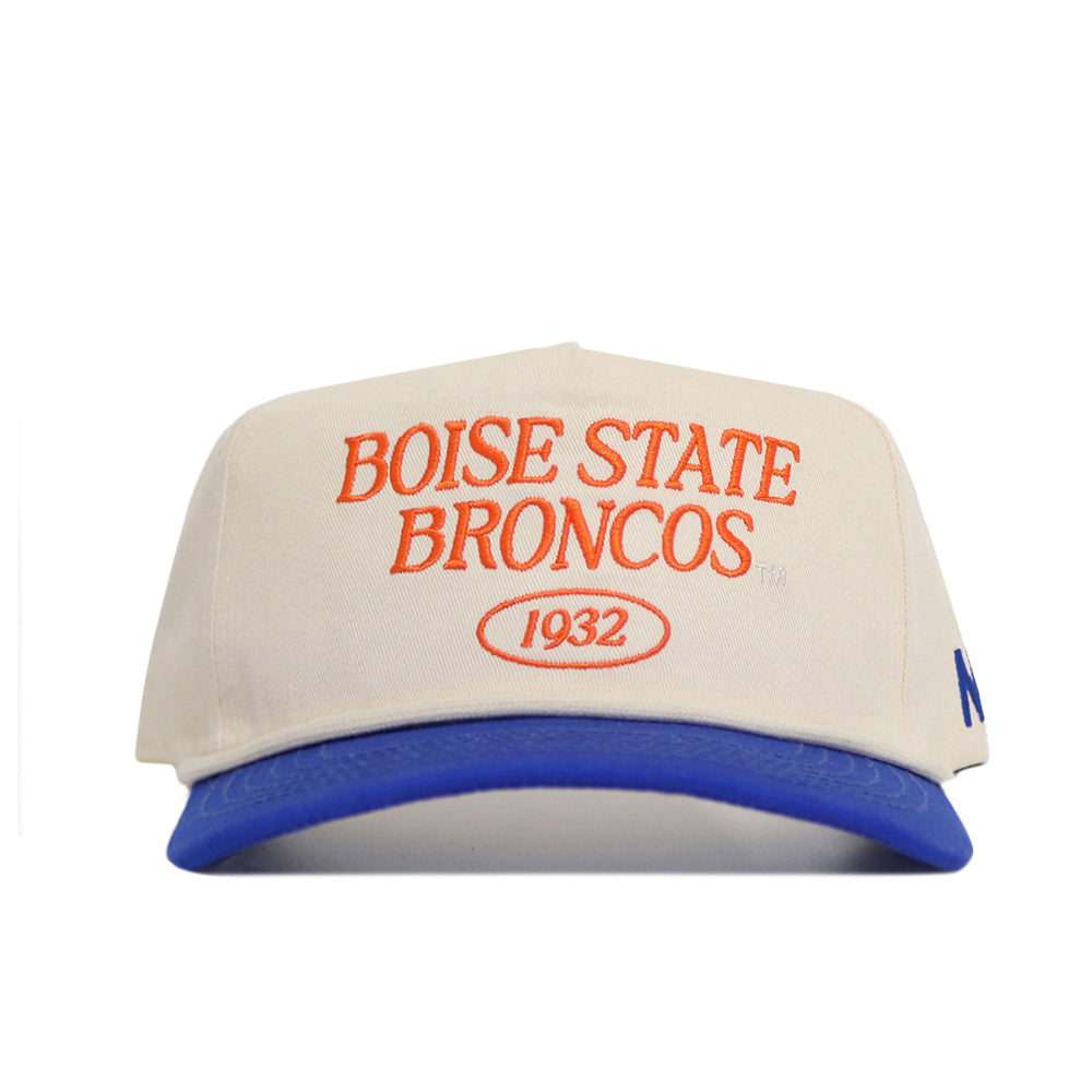 The Boise State Old School Hat (B2B) by No Rivals is a beige cap with "Boise State Broncos 1932" in orange, a blue bill, unstructured fit for comfort, and an adjustable snap back for one-size-fits-most wear.