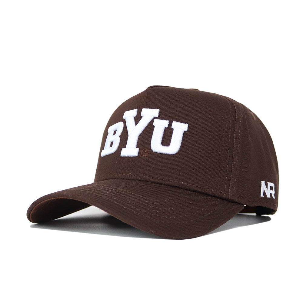 The BYU Americano Hat is a structured brown baseball cap featuring large white BYU letters on the front, small white NR branding on the side, and a classic snapback closure.