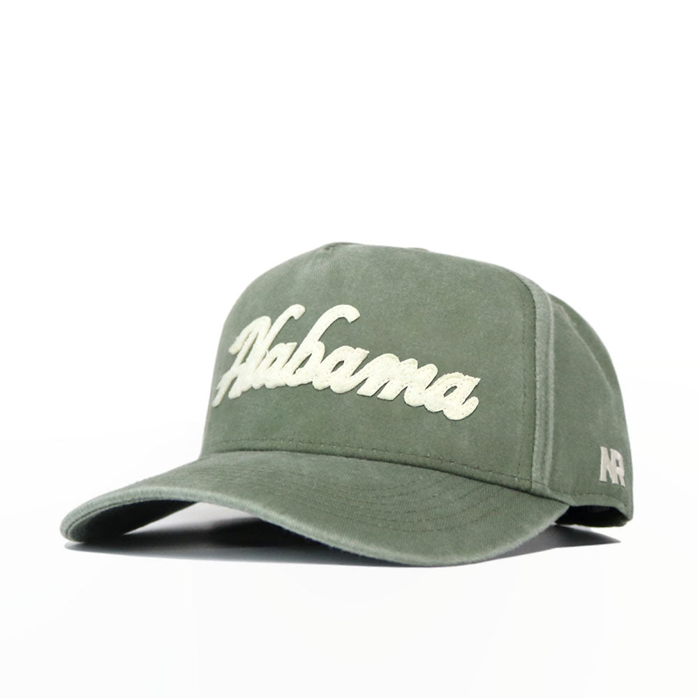 The Alabama Home Turf Hat is a green washed cotton cap with "Alabama" embroidered in white script on the front and "A R" stitched on the left side, featuring a snapback closure for adjustable comfort.