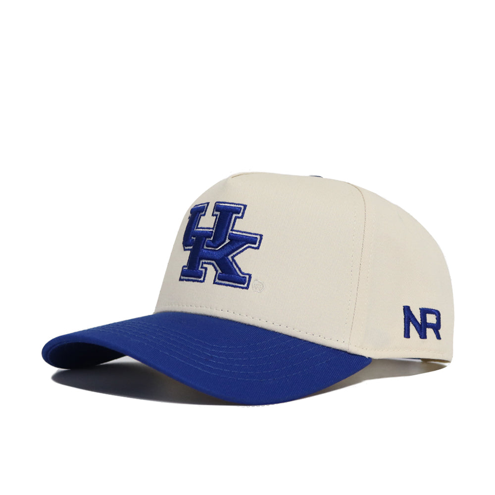 The Classic University of Kentucky Hat (B2B) by No Rivals is a cream baseball cap with a blue bill, large blue UK logo on the front, and NR initials on the side. This officially licensed snap back offers style and comfort.