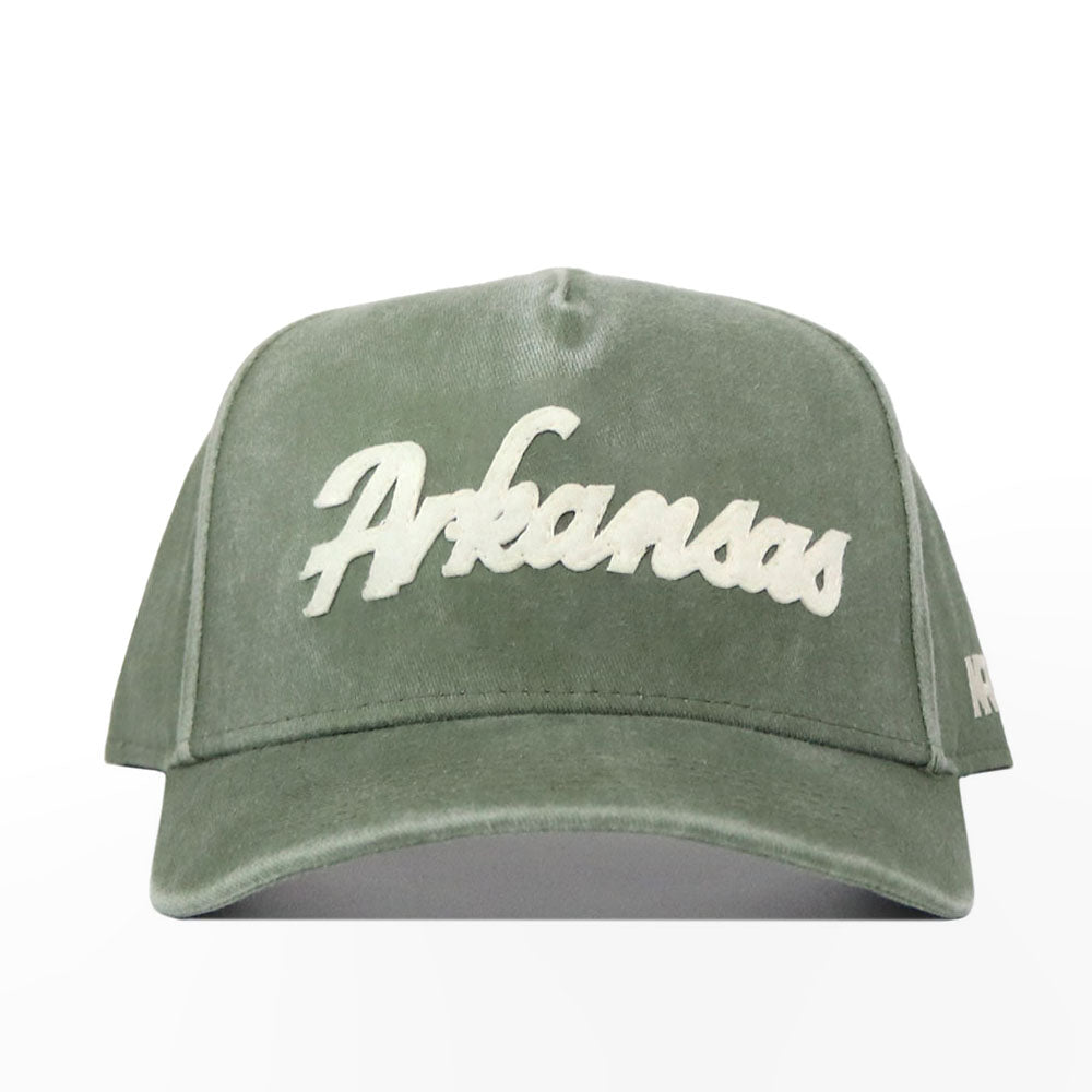 The Arkansas Home Turf Hat is a green structured fit cap featuring "Arkansas" embroidered in large white script on the front, shown against a plain white background.