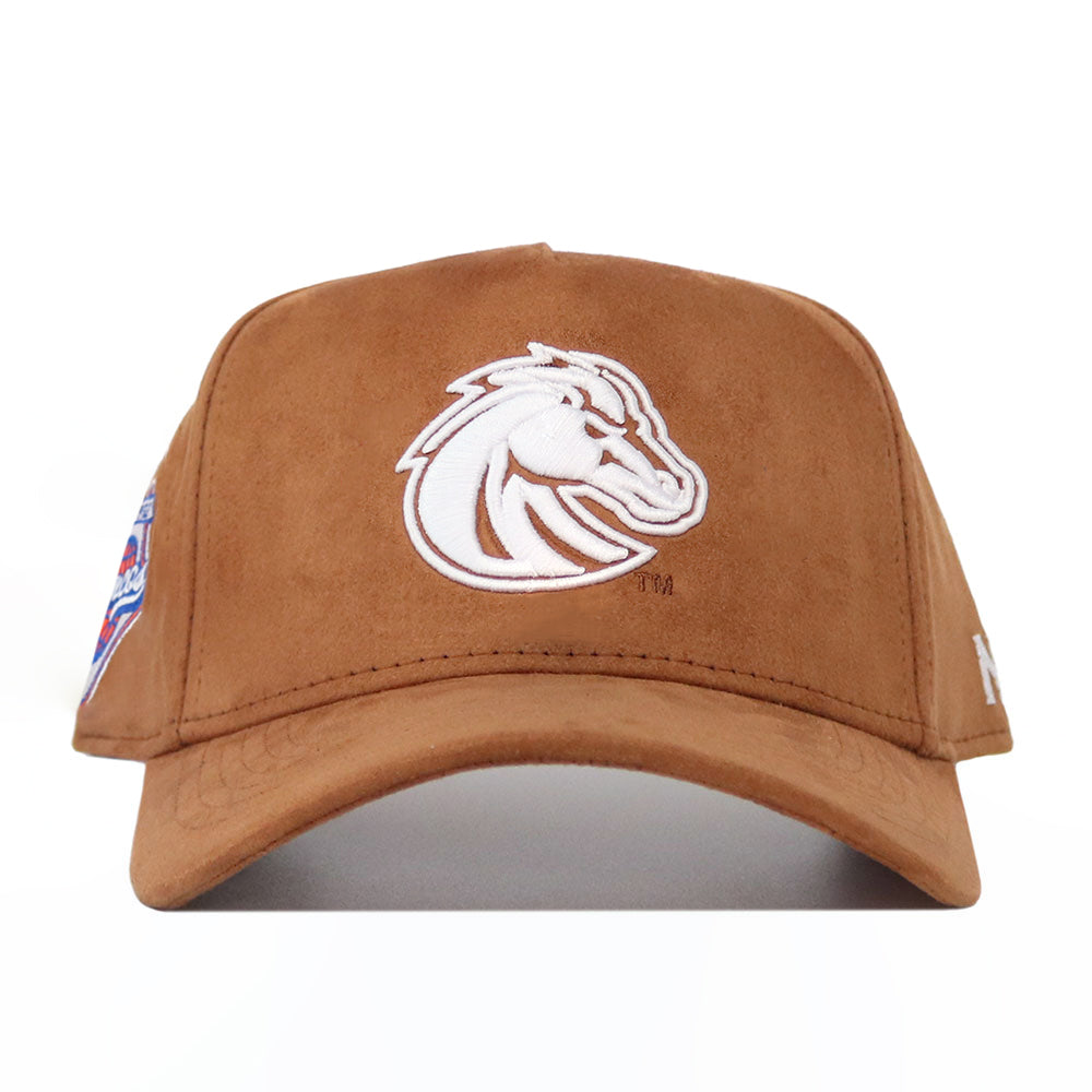 The No Rivals Boise State Heritage Hat is a brown suede baseball cap with a white embroidered horse head logo on the front, a multicolored patch on the left, and a small white logo on the right side.