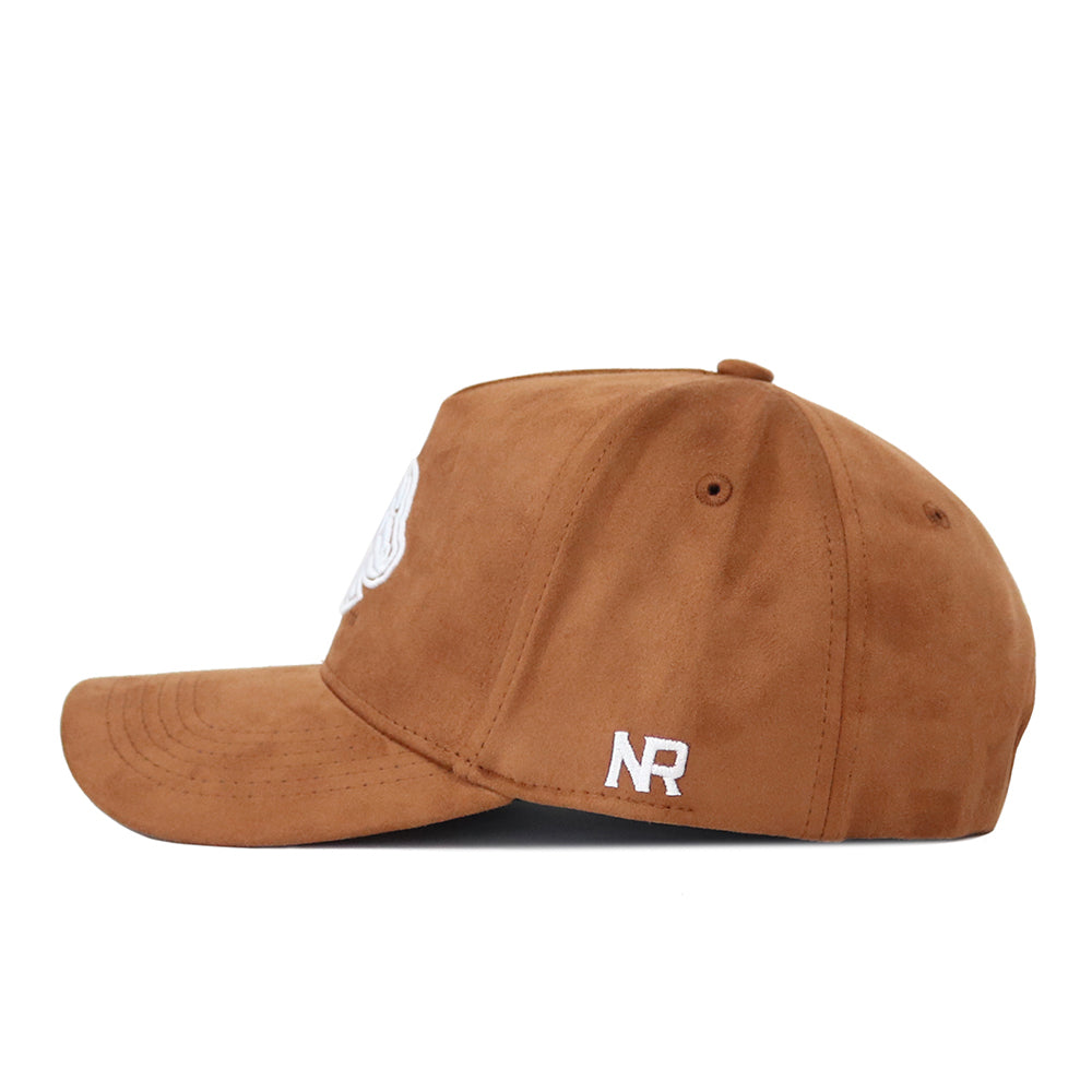 The No Rivals Boise State Heritage Hat is a brown suede fabric cap shown from the side, with white embroidered NR near the back, subtle panel seams, and a classic snapback closure for adjustable fit.