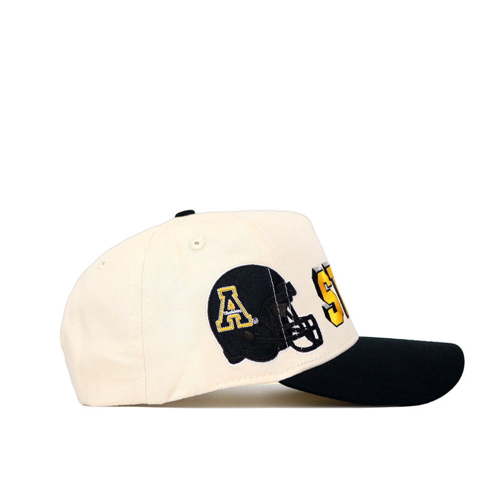 The No Rivals App State Alma Mater Hat - Classic features a cream crown, black brim, and an embroidered black football helmet with a yellow A and bold yellow letters. This structured cap offers a snap back closure for comfort.