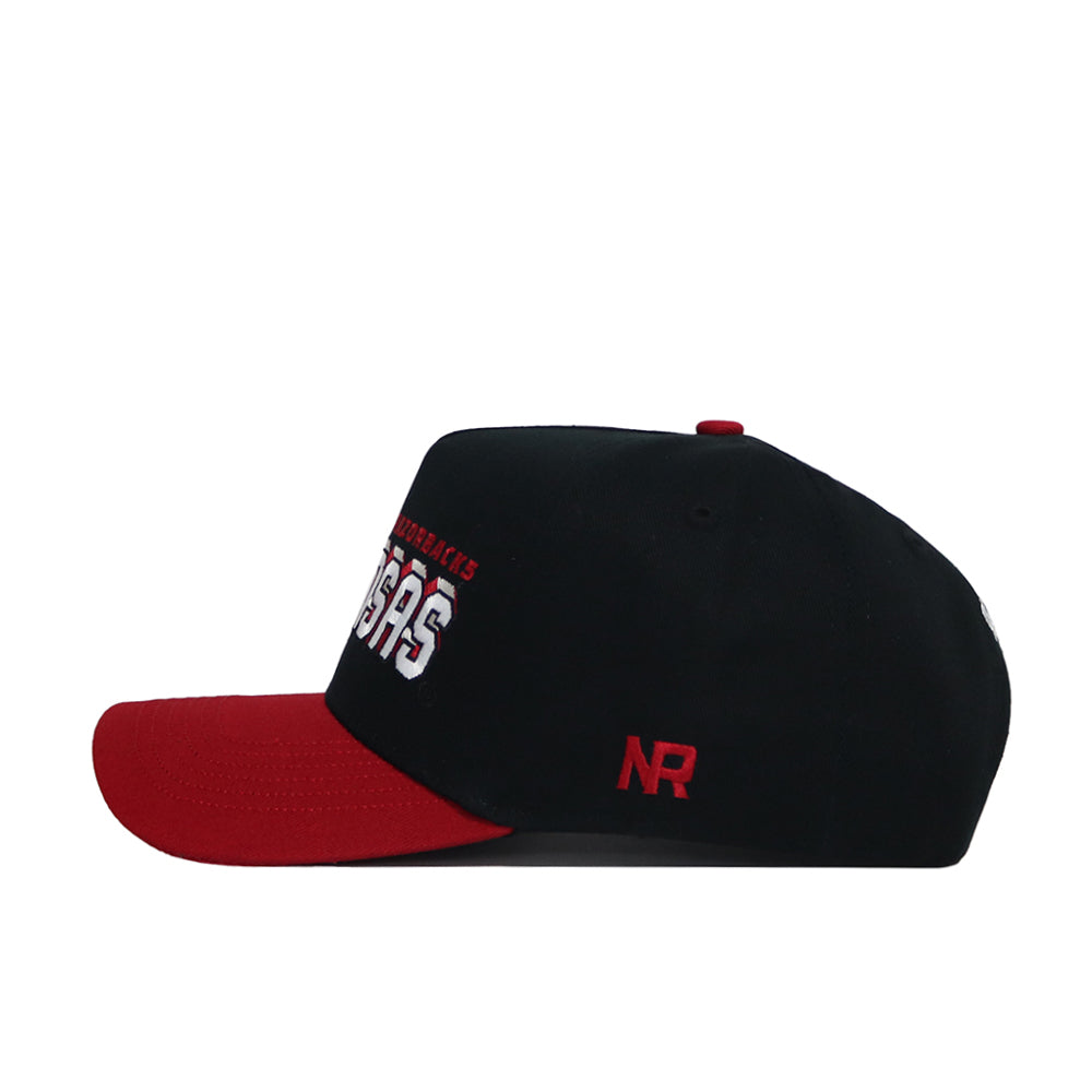 The Arkansas Courtside Hat is a black snapback with a red brim, embroidered white and red front text, and an NR logo on the side. Made from high-quality cotton, this structured cap is shown in a side profile on a white background.