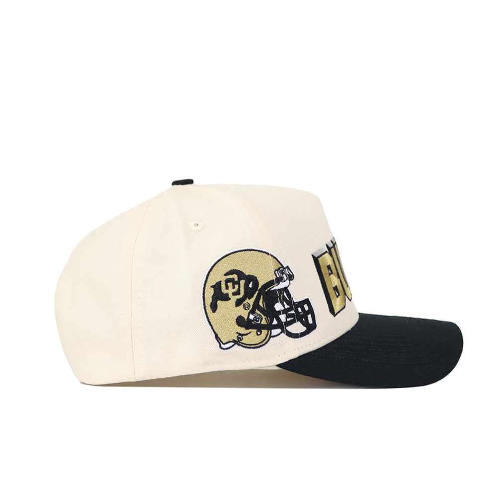 The Colorado Alma Mater Hat is a cream snapback with a black brim, featuring an embroidered gold football helmet with CU letters and buffalo logo, plus "BUFFS" in bold black and gold on the side. Made from high-quality cotton for structure.