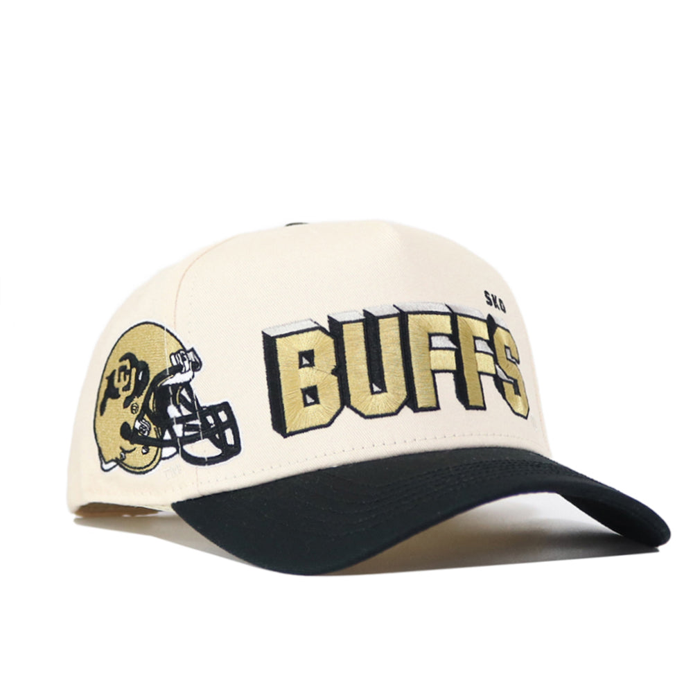 The Colorado Alma Mater Hat is a cream and black snapback featuring a football helmet graphic and bold gold-and-black BUFFS text on the front, made from high-quality cotton for a comfortable, structured fit.