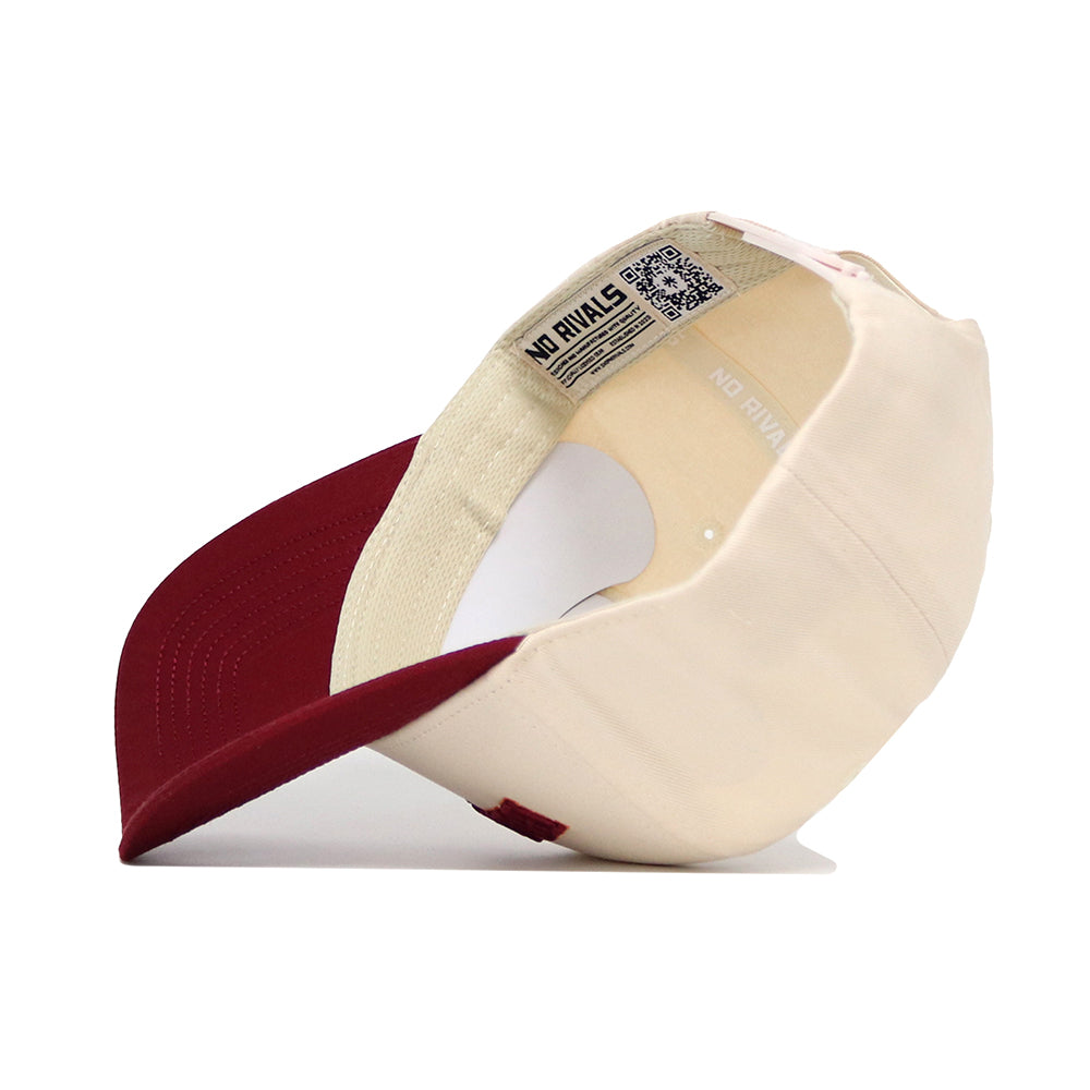 The Blacksburg Hometown Hat by No Rivals is a cream and red snapback, shown upside down to reveal its structured cotton interior, a NO RIVALS label, and a QR code near the band. The brim is red and the crown is cream.