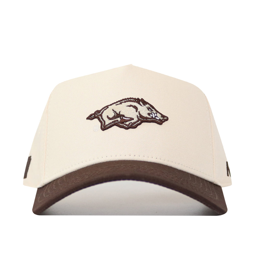The No Rivals Arkansas Espresso Hat is a cream-colored cap with a brown brim, made from high-quality cotton. It features a snapback closure and an embroidered wild boar logo on the front panel.
