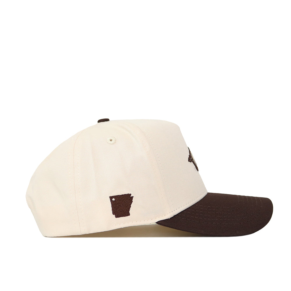 The No Rivals Arkansas Espresso Hat features a cream crown and dark brown brim, crafted from premium cotton. A small, dark brown embroidered outline of Arkansas decorates the side panel for a distinctive touch.