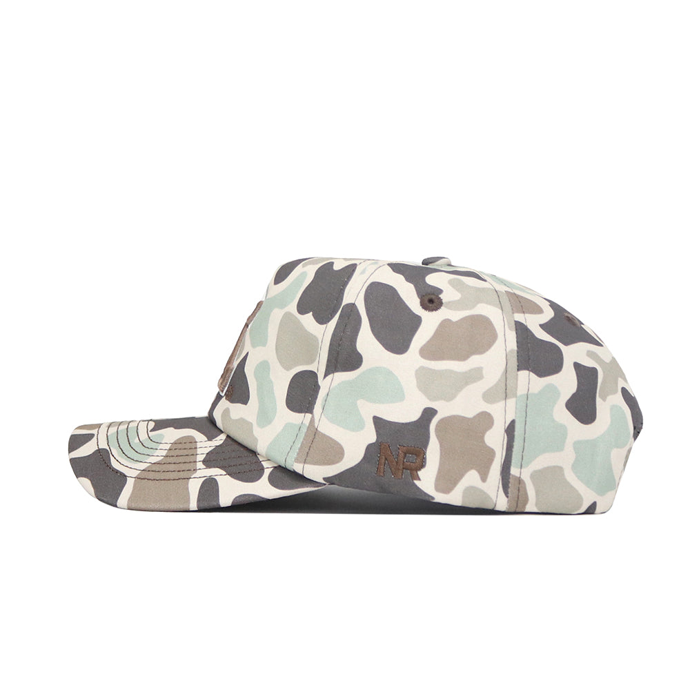 A side view of the No Rivals Arizona Huntsman Hat, a 5-panel cap in green, beige, and brown duck camo with a curved brim, "NP" embroidered in brown on the side, and a snap back closure for adjustable fit.