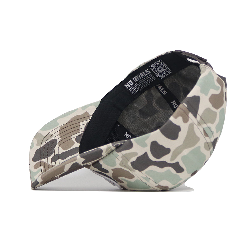The BYU Huntsman Hat by No Rivals, a 5-panel duck camo cap, is displayed upside down on a white background to show the interior label and stitching.