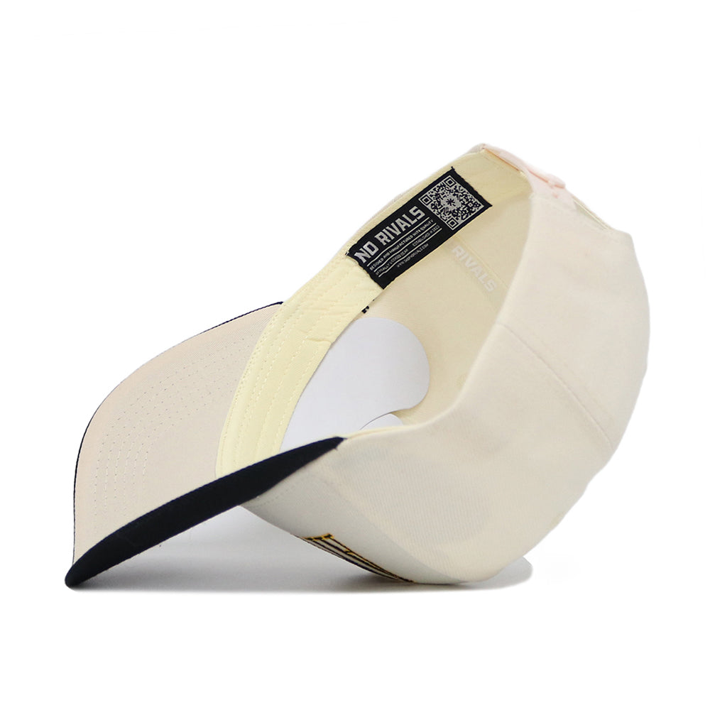The App State Retro Block Hat by No Rivals is shown upside down, revealing its inside label and a QR code on the inner tag. This cream-colored snapback features a black brim and structured fit.