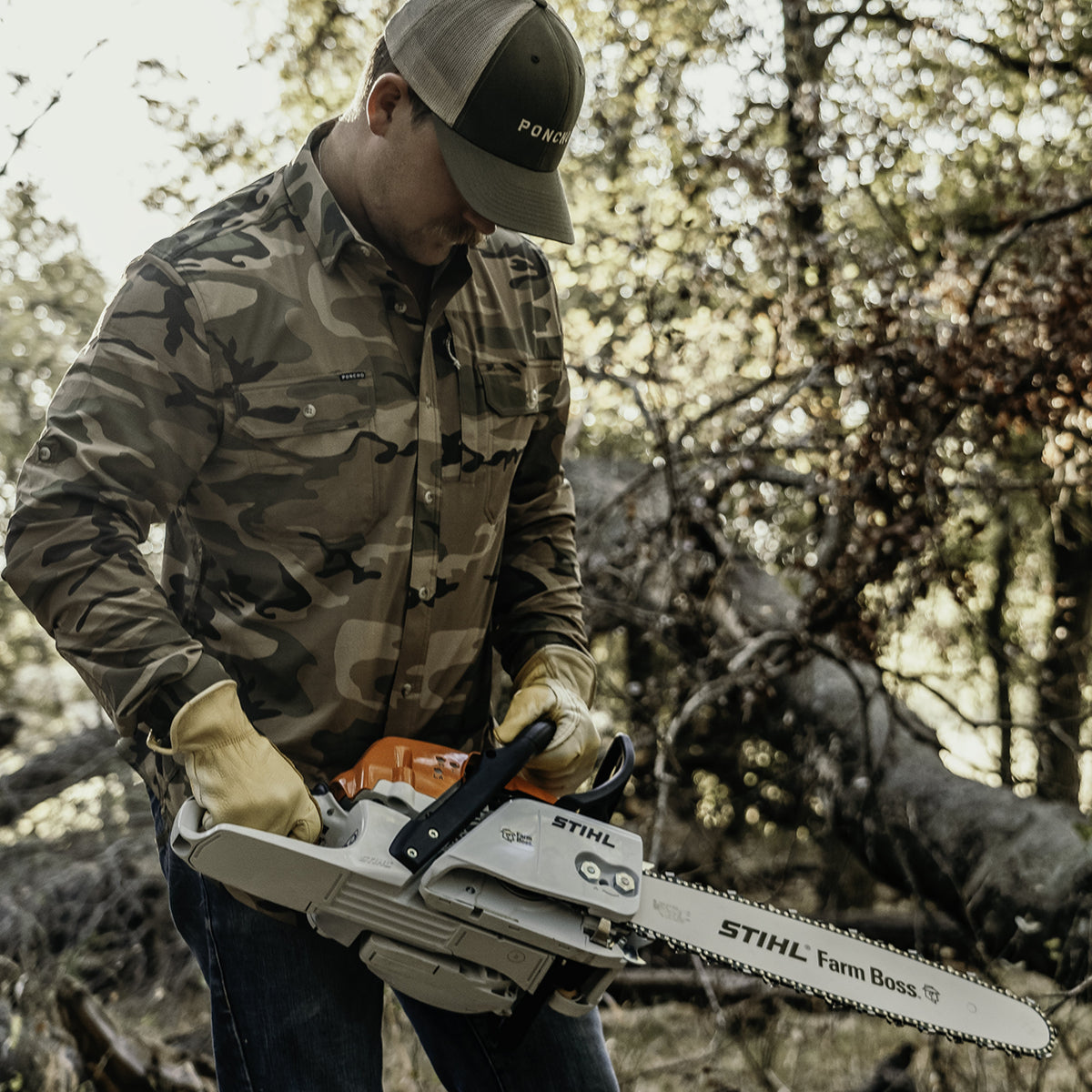man wearing long sleeve camo shirt with chainsaw