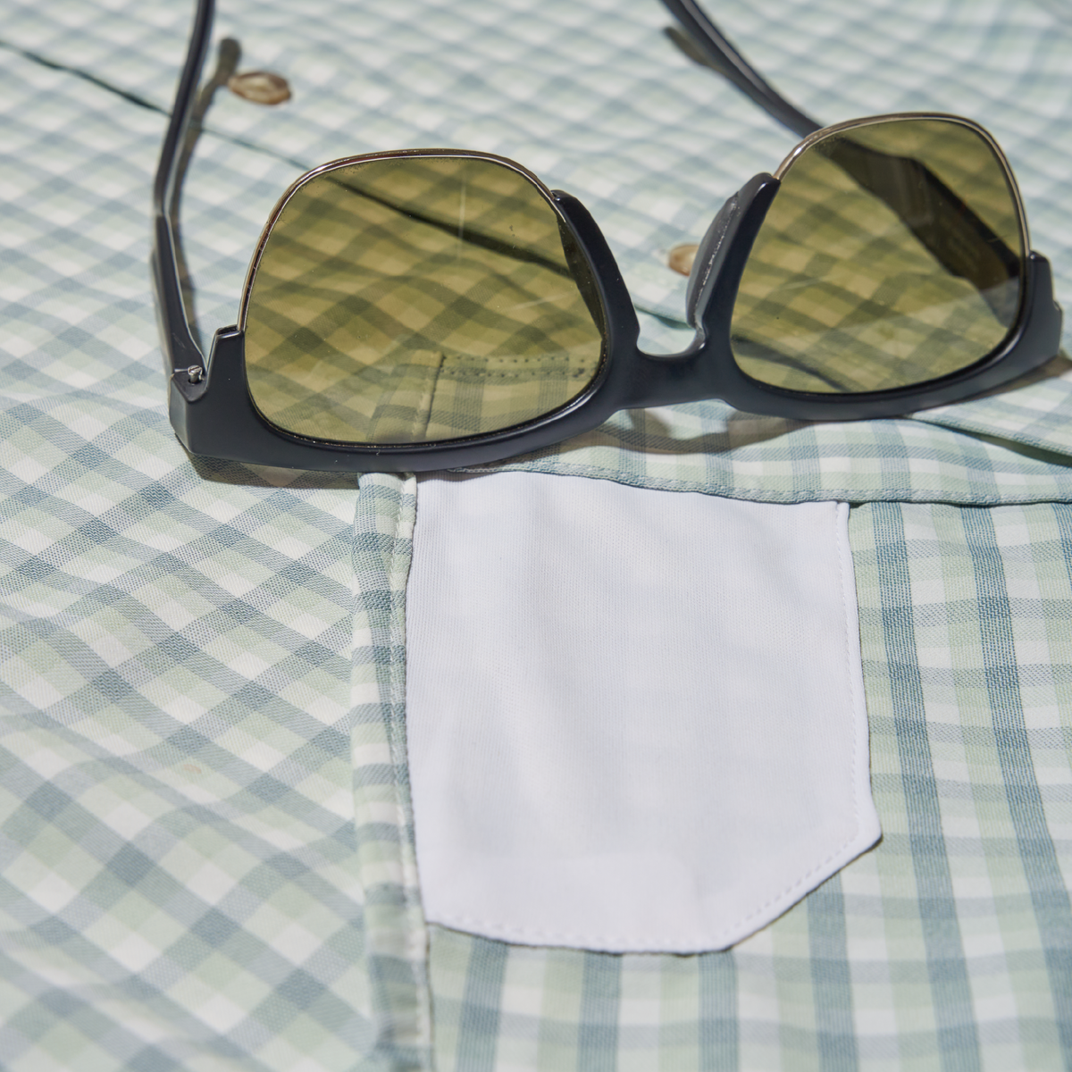 closeup of shades and lens cleaner on shirt