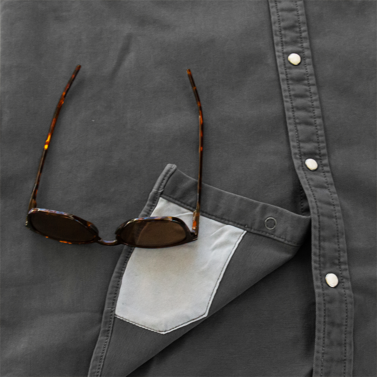 sunglasses with lens cleaner on shirt