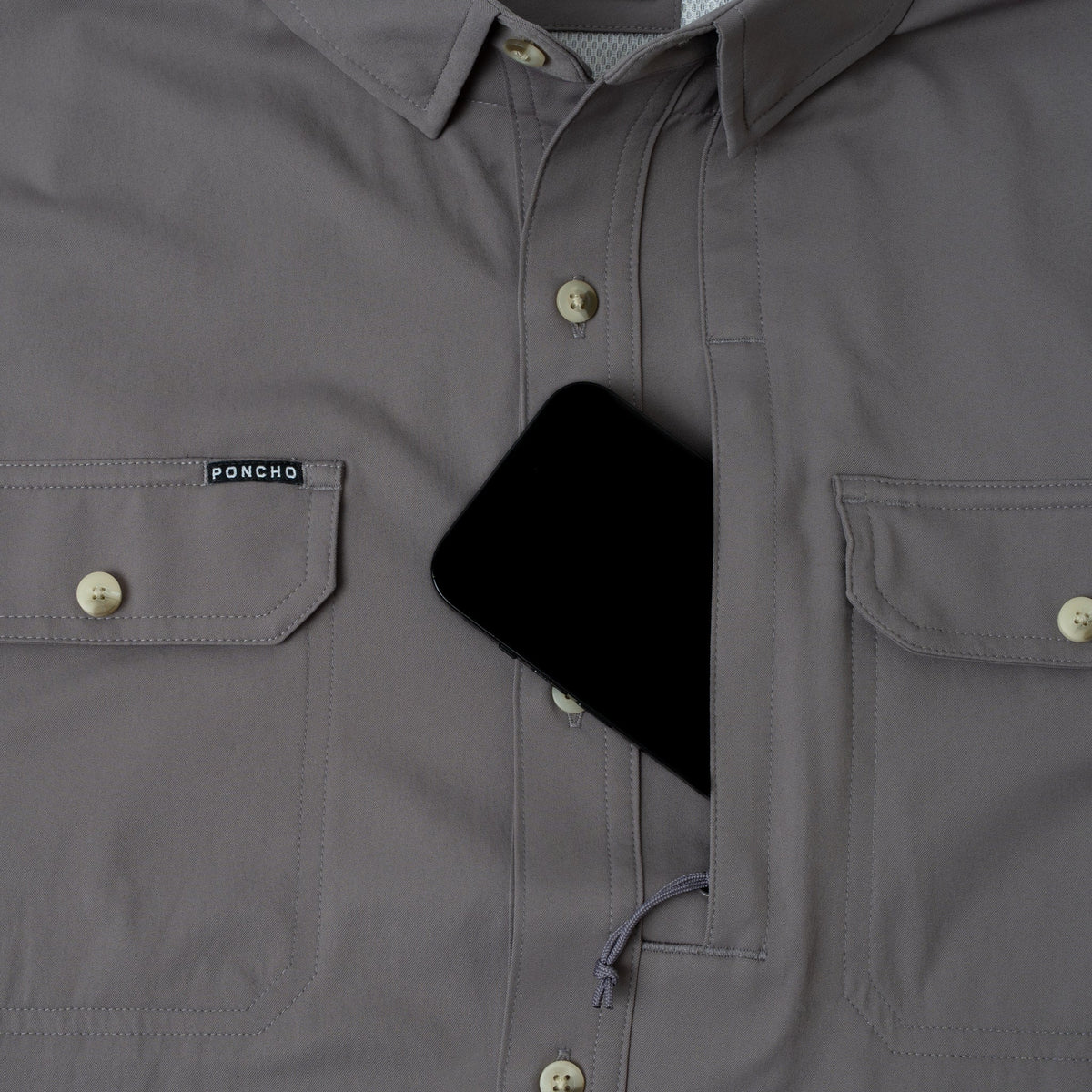 phone in chest pocket of grey button down fishing shirt
