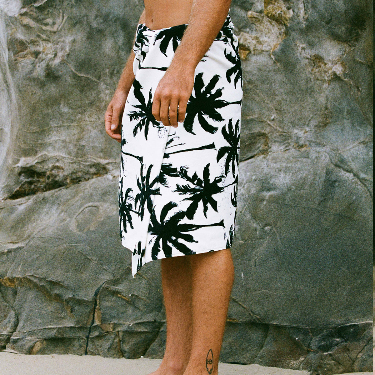 Velour towel with palm tree print.