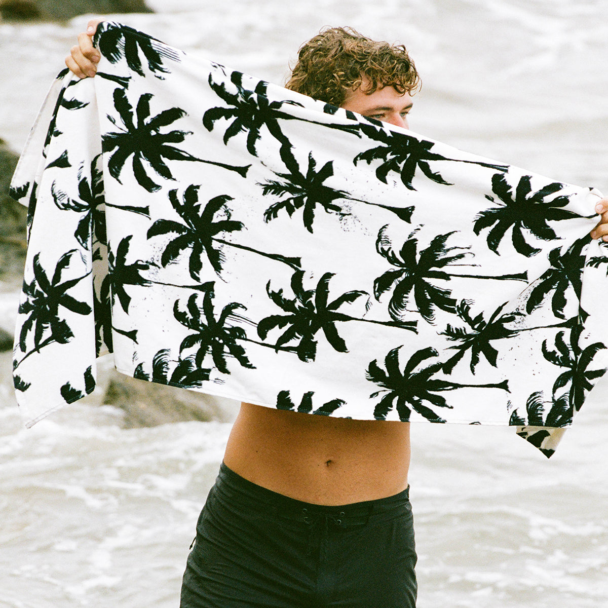 Beach towel, sustainably sourced cotton, white with black palm tree print.