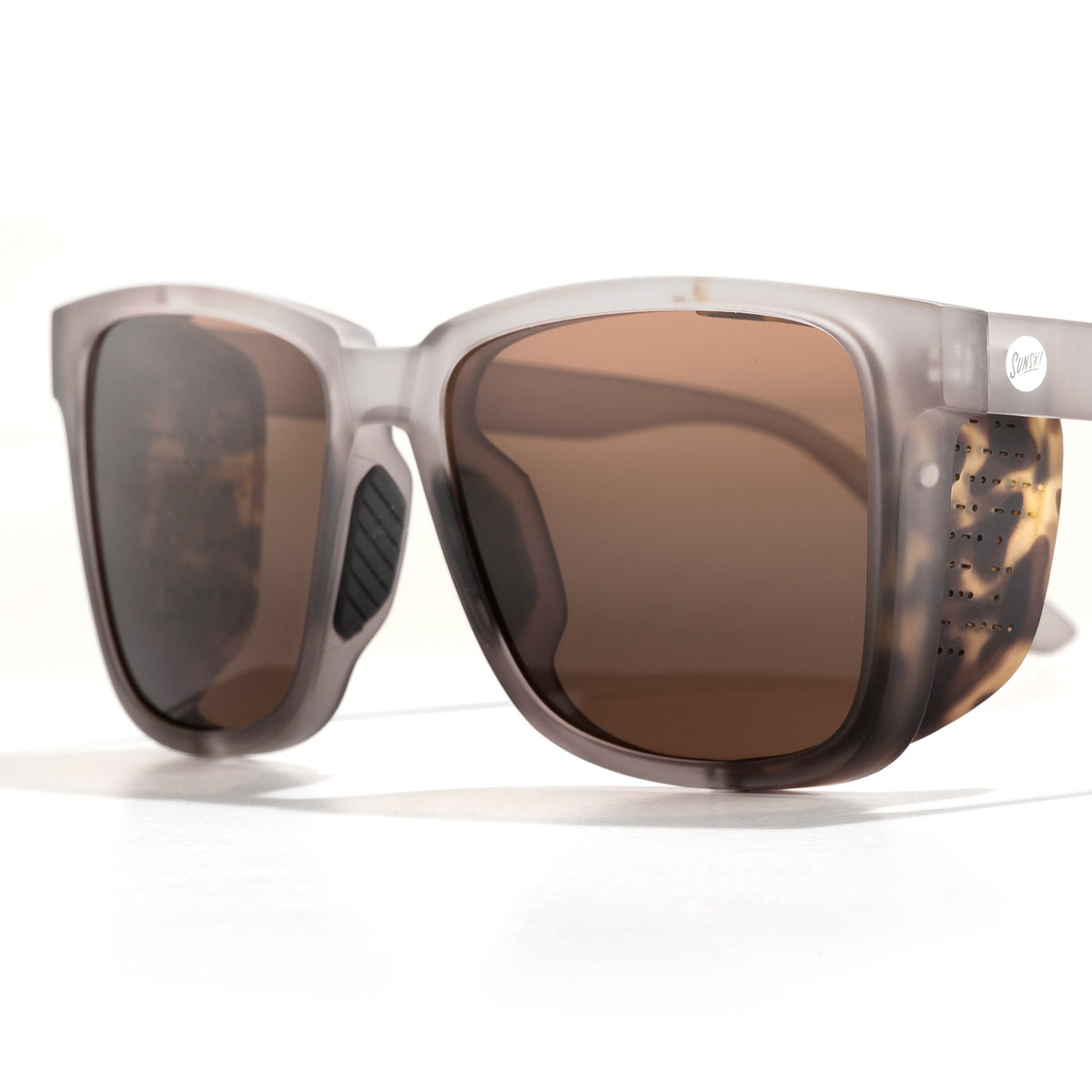 Sunglasses with tortoiseshell frame and brown lenses on a white background
