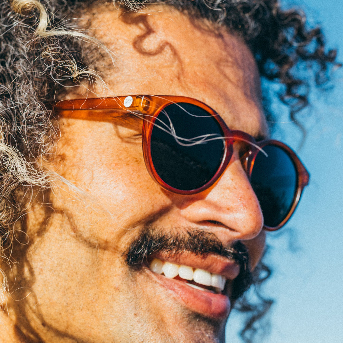 Man wearing sunglasses with a blue sky background