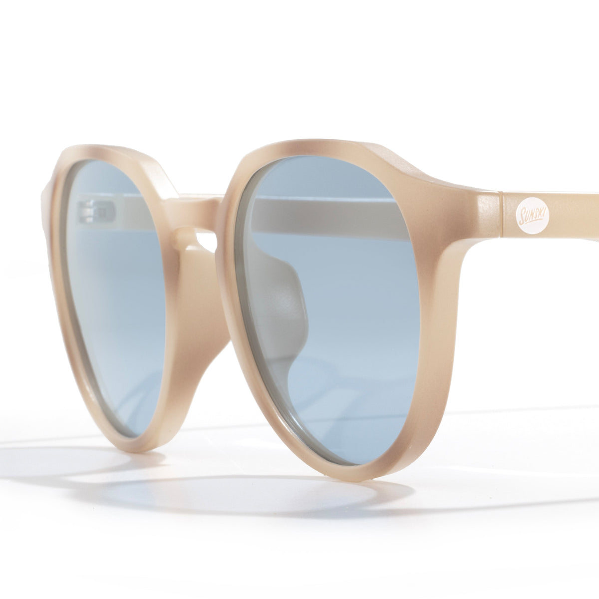 Beige sunglasses with blue lenses on a white background