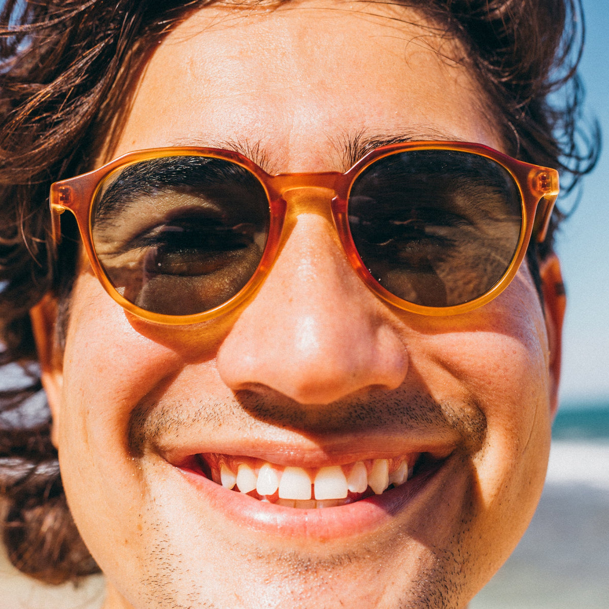 Close-up of a person wearing sunglasses with a blurred background
